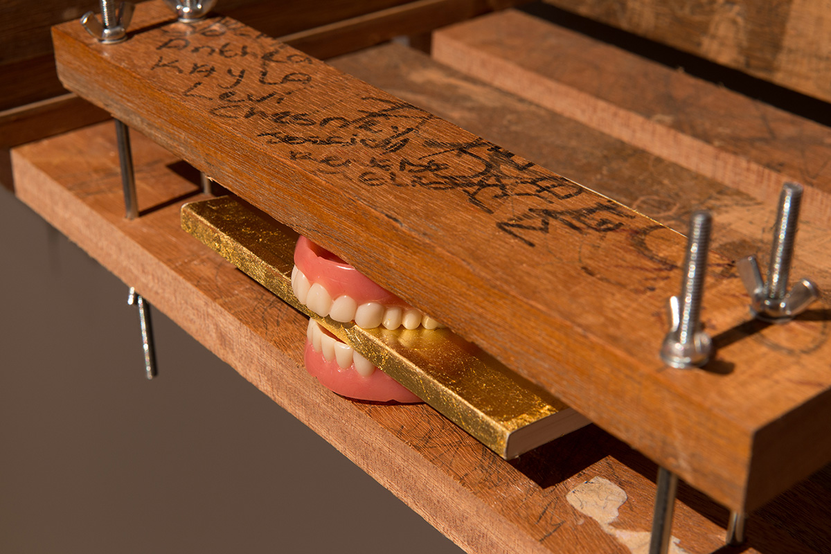 Kemang Wa Lehulere, Once bitten, twice shy [Detail], 2016. Salvaged school desks, dentures, gold-leaf-covered books, steel